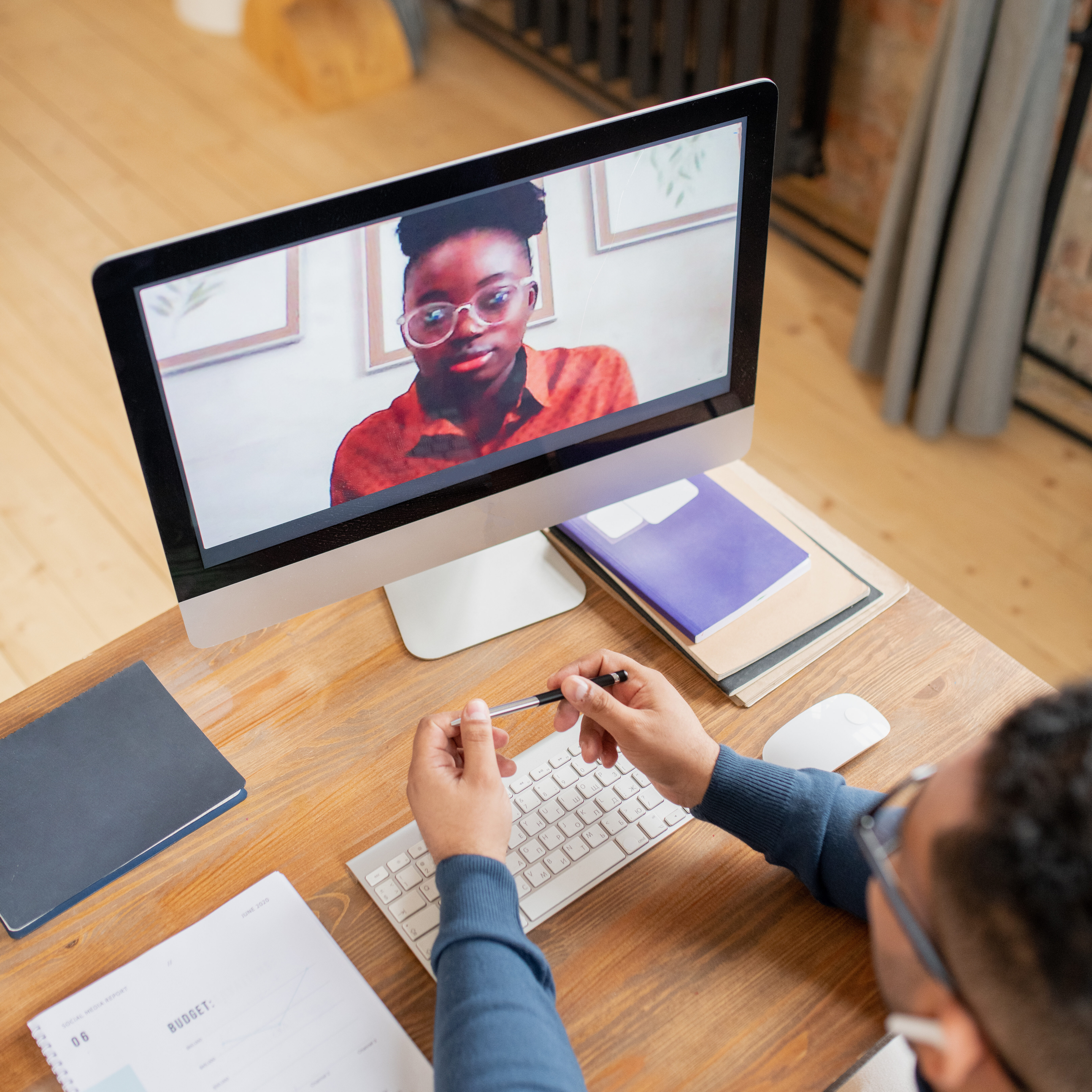 LRCE students meets with mentor Person participating in a virtual meeting or online class on a desktop computer, taking notes with a pen and notebook. Ideal for showcasing LRCE's flexible and accessible teacher certification programs offered remotely.